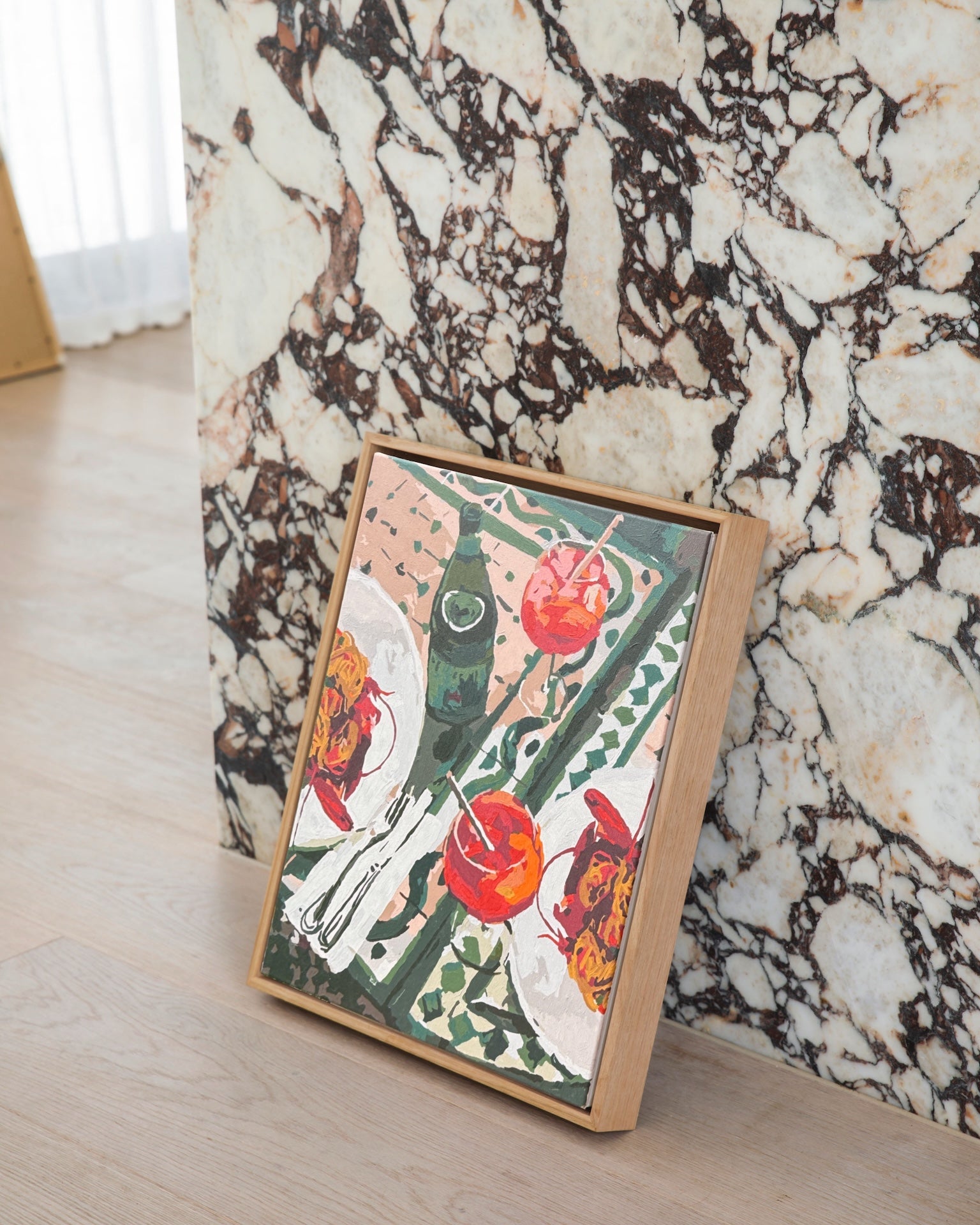Paint Like Frida’s Frutti di Mare and Aperol Spritz Big Framed Canvas, styled against marble and timber — a summer-inspired paint by numbers kit with seafood pasta, Aperol spritzes and a green bottle, in a custom floating frame.